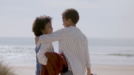 Two-American-Siblings-Hugging-At-The-Beach-On-Sunny-Day