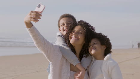 Glückliche-Amerikanische-Mutter-Und-Zwei-Kinder,-Die-Selfie-Machen,-Während-Sie-Zeit-Am-Meer-Verbringen