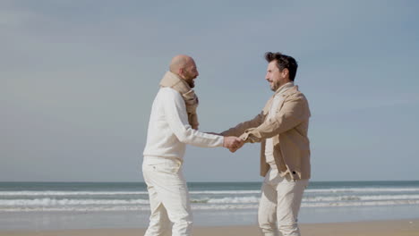 Kamerafahrt-Eines-Glücklichen-Schwulen-Paares,-Das-Am-Strand-Tanzt-1