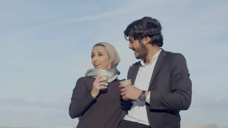Arabic-Couple-Standing-Outdoor-And-Drinking-Coffee-While-Talking