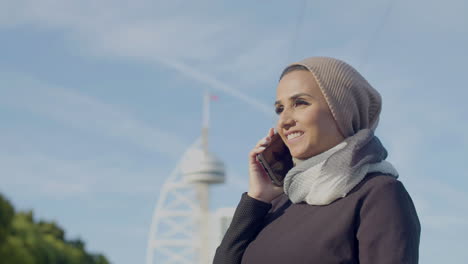 Mujer-árabe-Feliz-Hablando-Con-Su-Novio-Por-Teléfono-Al-Aire-Libre