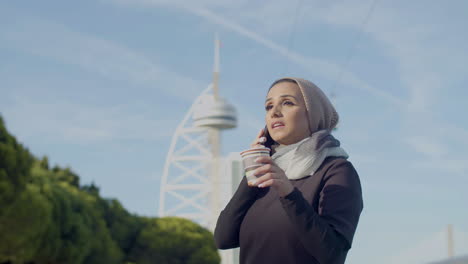 Schöne-Frau-Im-Hijab-Trinkt-Kaffee-Und-Spricht-Am-Telefon