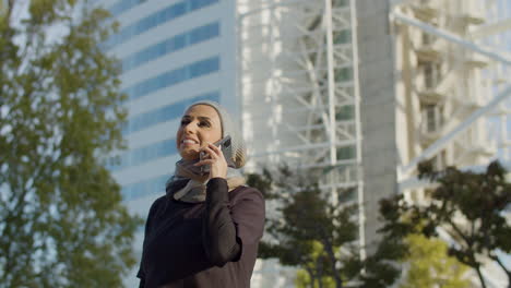 Bella-Mujer-árabe-Con-Hiyab-Hablando-Por-Teléfono-Fuera-Del-Edificio