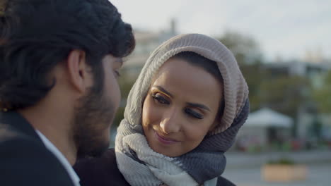 Cute-Woman-In-Hijab-Looking-At-Boyfriend-While-Dating-Outdoors