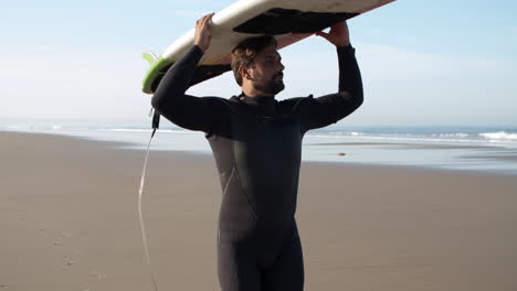 Vertikale-Bewegung-Eines-Männlichen-Surfers-Mit-Beinprothese,-Der-Mit-Einem-Surfbrett-Auf-Dem-Kopf-Am-Strand-Spazieren-Geht