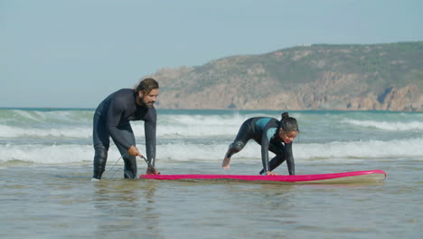 Long-Shot-Of-Father-Teaching-His-Daughter-Surfing