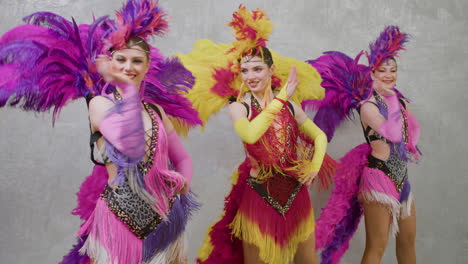Group-Of-Female-Performers-In-Feathers-Gowns-Dancing-And-Moving-Their-Hands-Side-To-Side