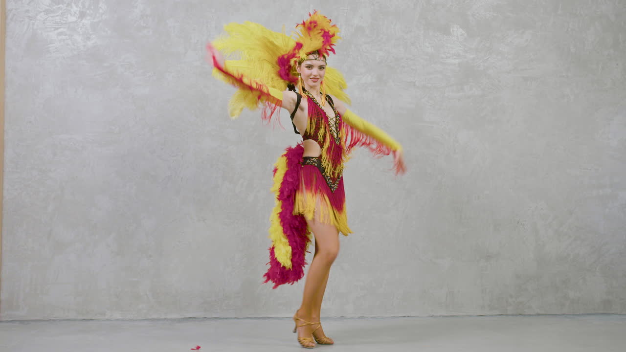 Premium stock video - Young beautiful woman in red and yellow feather ...