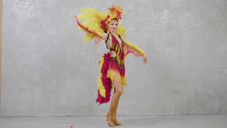 Junge-Schöne-Frau-Im-Roten-Und-Gelben-Federkleid,-Das-Samba-Tanzt