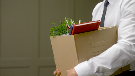 Close-Up-Of-A-Unrecognizable-Employee-Leaving-The-Office-With-His-Personal-Stuff-In-A-Box-1
