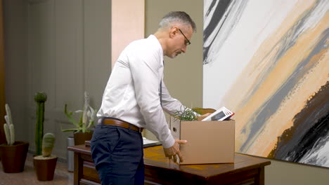 Mature-Man-Thinking-About-The-Resignation-And-Leaving-The-Office-With-His-Supplies-In-A-Box