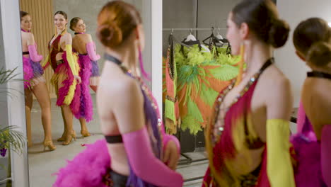 Bellas-Damas-Mostrando-Sus-Movimientos-Frente-A-Un-Espejo-Con-Vestidos-De-Plumas