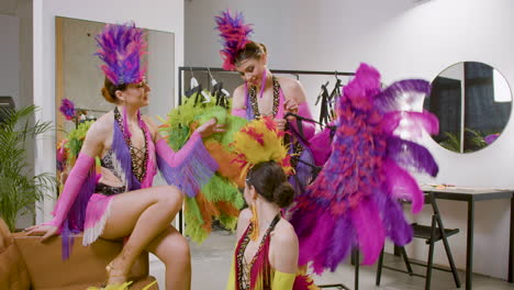 Beautiful-Dancers-Having-Fun,-Talking-And-Getting-Ready-In-Feather-Gowns