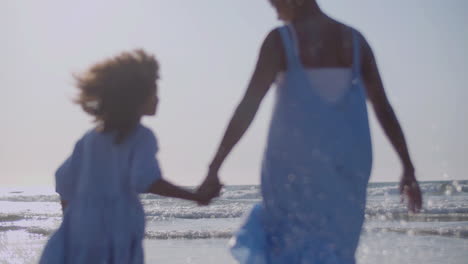 Loving-Mother-And-Her-Cute-Daughter-Walking-Hand-In-Hand-At-Seashore