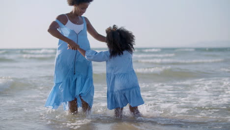Liebevolle-Mutter-Und-Ihre-Süße-Tochter-Tanzen-Zusammen-Und-Haben-Spaß-Im-Meer