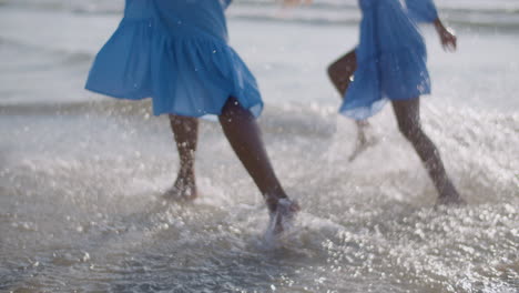 Close-Up-Of-Mother-And-Daughter-Running-On-Water-At-Sea-Beach
