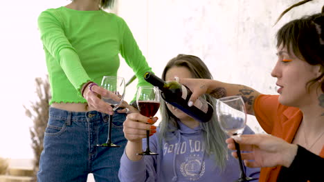 Close-Up-Of-A-Girl-With-Tattoos-And-Dreadlocks-Pouring-Wine-For-Friends-During-A-Fun-Party-At-Home