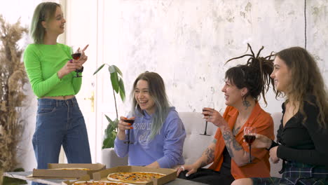 Cheerful-Female-Friends-Drinking-Wine,-Talking-And-Giving-High-Five-During-A-Fun-Party-At-Home