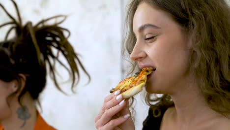 Nahaufnahme-Einer-Jungen-Frau,-Die-Zu-Hause-Ein-Stück-Pizza-Mit-Freunden-Isst