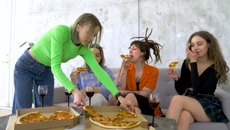 Happy-Four-Female-Friends-Eating-Pizza-And-Talking-At-Home