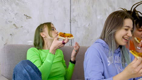 Zoom-In-Of-A-Happy-Girl-Talking-And-Eating-A-Slice-Of-Pizza-During-A-Party-With-Friends-At-Home