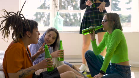 Group-Of-Four-Female-Friends-Talking-And-Laughing-While-Drinking-Beer-At-Home