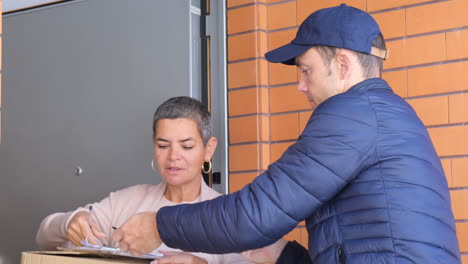 Woman-Signing-For-Receiving-Parcel-On-Clipboard-At-Her-Home
