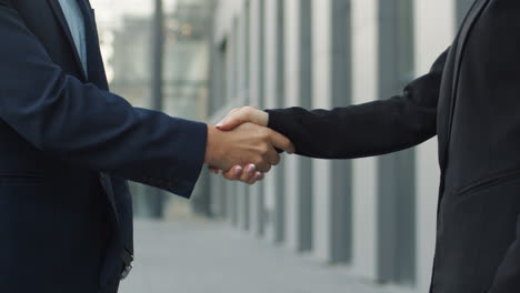 Close-Up-View-Of-Businessman-And-Businesswoman-Shaking-Hands-In-The-Street