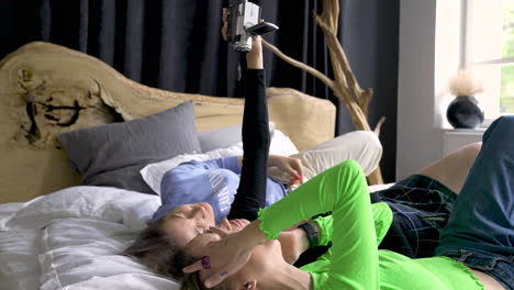 Three-Young-Woman-Recording-With-Video-Camera-On-A-Bed