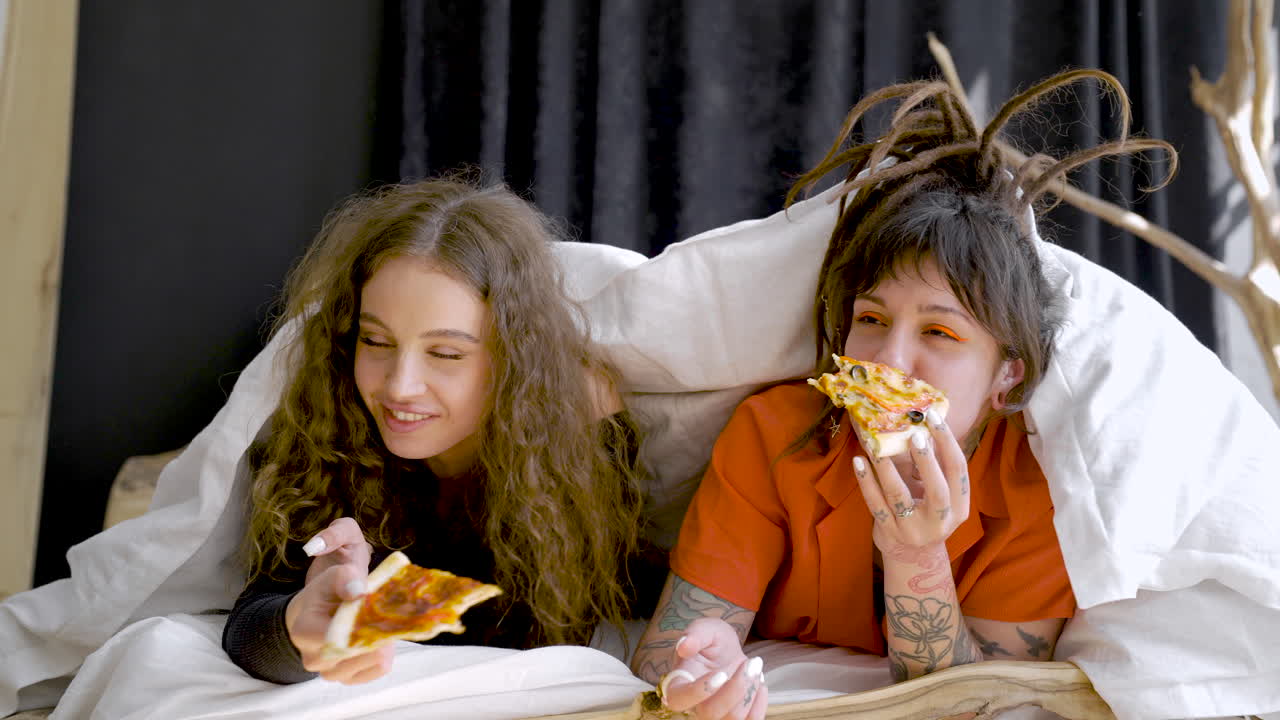 1280px x 720px - Premium stock video - Young girl friends laying on bed while talk and eat  pizza