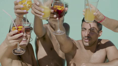 Medium-Shot-Of-Happy-Teenagers-Clinking-Glasses-In-Swimming-Pool