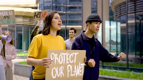 Mujer-Y-Hombre-Sosteniendo-El-Cartel-De-Proteger-Nuestro-Planeta-En-Una-Protesta