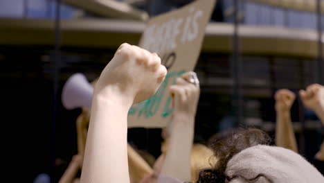 Mujer-Judía-Morena-Protestando-Junto-A-Personas-Con-Pancartas