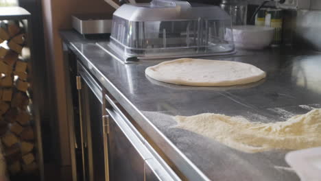 Close-Up-View-Of-Flour-And-Pizza-Dough-On-A-Restaurant-Kitchen-Countertop