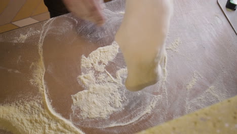 Top-View-Of-A-Chef-Kneading-Pizza-Dough-On-A-Restaurant-Kitchen-Countertop