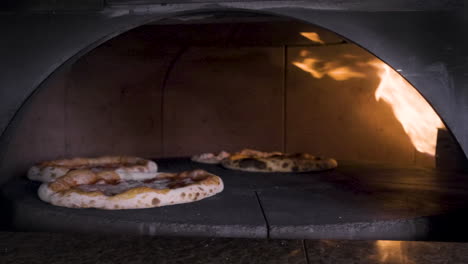 Pizzas-Spinning-In-The-Stone-Oven-In-A-Restaurant-Kitchen
