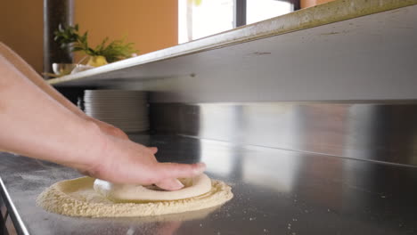 Close-Up-View-Of-A-Chef-Hands-Kneading-Pizza-Dough-On-A-Restaurant-Kitchen-Countertop