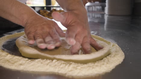 Close-Up-View-Of-A-Chef-Hands-Kneading-Pizza-Dough-On-A-Restaurant-Kitchen-Countertop-1