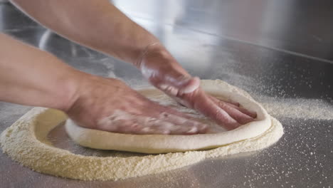 Close-Up-View-Of-A-Chef-Hands-Kneading-Pizza-Dough-On-A-Restaurant-Kitchen-Countertop-2