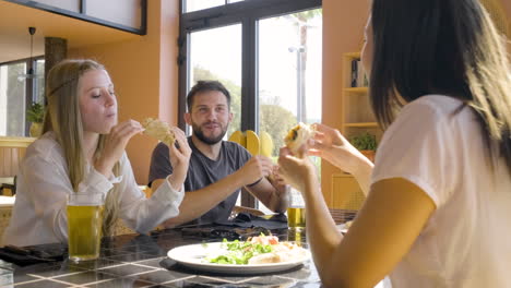 Close-Up-View-Of-Group-Of-Friends-Talking-And-Eating-Pizza-At-Restaurant-Table-1