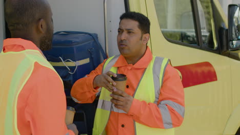 Latin-Ambulance-Driver-Drinking-Coffee-And-Talking-With-His-Black-Colleague