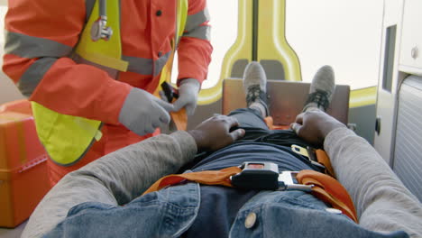 Hands-Of-A-Paramedic-Fastening-The-Seat-Belt-Of-A-Patient-Lying-On-The-Stretcher-Inside-An-Ambulance