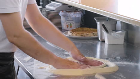 Close-Up-Of-An-Unrecognizable-Chef-Kneading-Pizza-Dough-On-A-Countertop-In-A-Restaurant