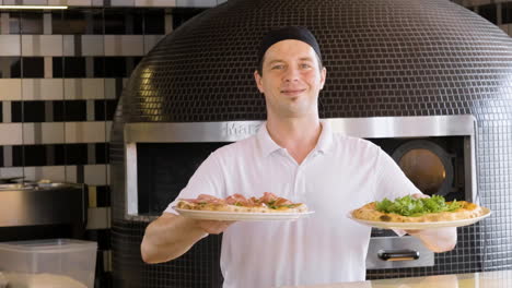 Happy-Chef-Showing-Pizzas-And-Smiling-At-The-Camera-In-The-Restaurant