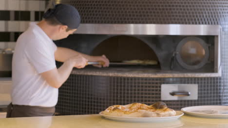 Chef-Moving-Pizza-With-Peel-In-The-Fired-Oven