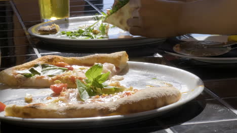 Primer-Plano-De-Una-Persona-Irreconocible-Comiendo-Pizza-En-El-Restaurante