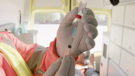 Close-Up-Of-An-Unrecognizable-Paramedic-Preparing-A-Syringe-And-Then-Injecting-The-Shot-To-An-American-Patient-In-The-Ambulance