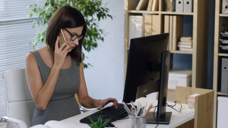 Pregnant-Businesswoman-In-Glasses-Working-At-The-Computer-In-The-Office-And-Talking-On-The-Phone-1