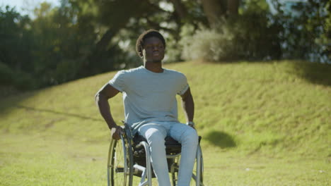 Front-View-Of-Black-Man-In-Wheelchair-Enjoying-Ride-In-Park