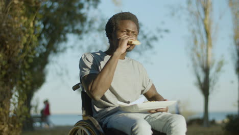 Low-Angle-Shot-Of-Young-Man-In-Wheelchairt-Enjoying-His-Snack
